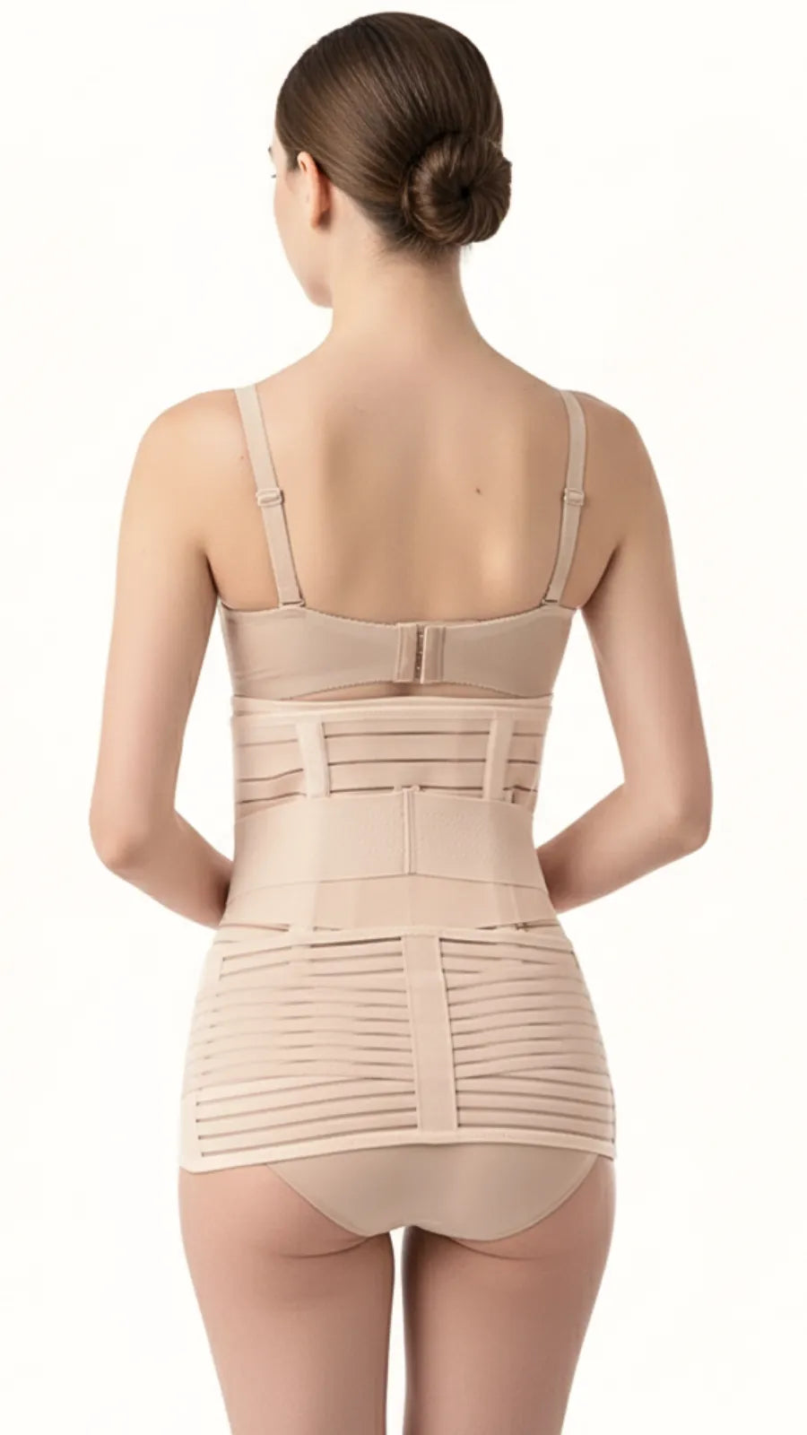 Back view of a woman wearing a beige postpartum recovery support belt with lumbar support on a white background.