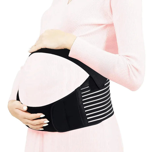 Pregnant woman wearing a black maternity belt support band on a white background.